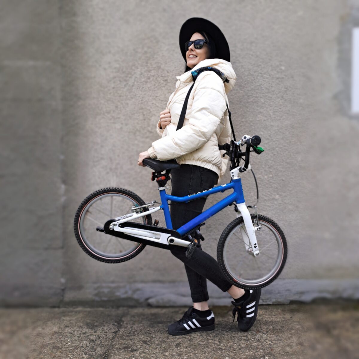 pas do noszenia rowerka i hulajnogi kobieta trzyma rowerek na pasku